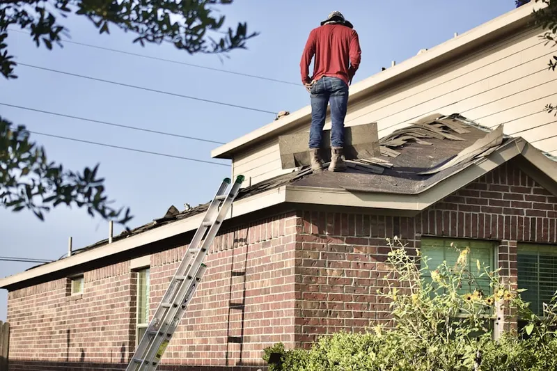 Professional roofer working on a residential roof in Rainey